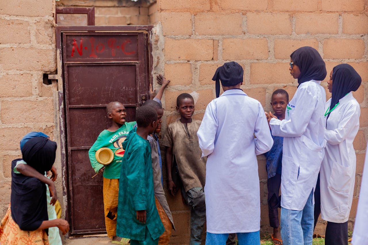 Healthcare workers engage with children in Gombe, Nigeria, promoting community health awareness.